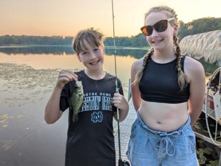 Anton and Yelena with a little crappie that they caught on the dock, July 2025.