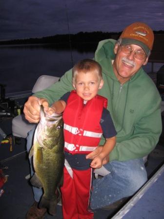 Walker P. with Grandpa Jim N. and a nice 18-inch largemouth bass they caught and released on Benoit Lake, July 19, 2009.